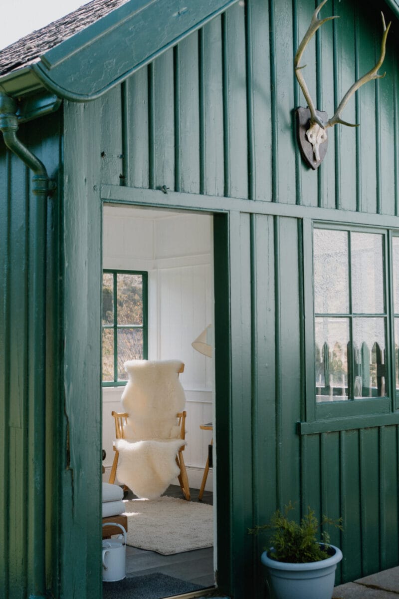 Green timber garden room with its door open at Cairn Valley Cottage, Rothiemurchus, Aviemore