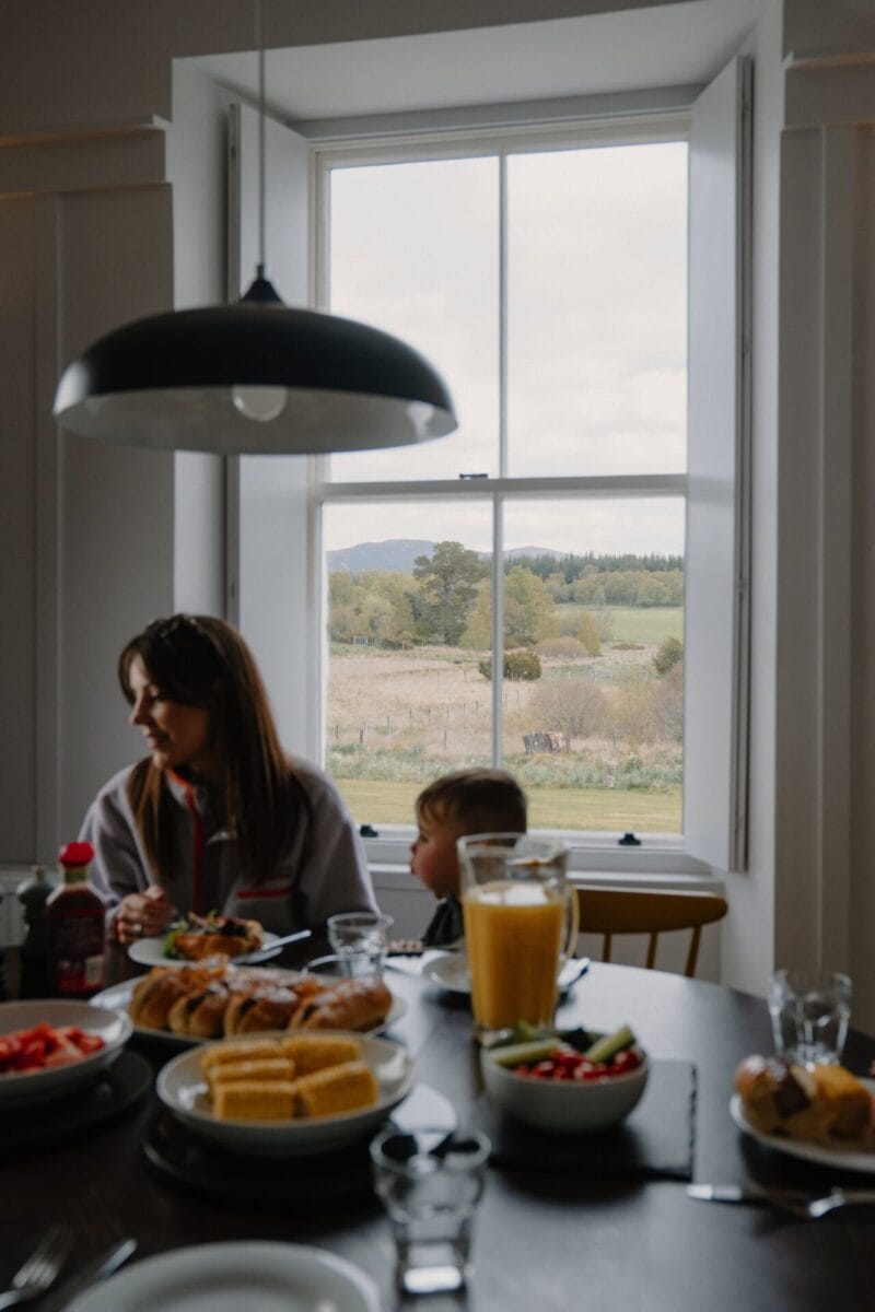 Family meal by the window at Achnahatnich House, Rothiemurchus, Aviemore