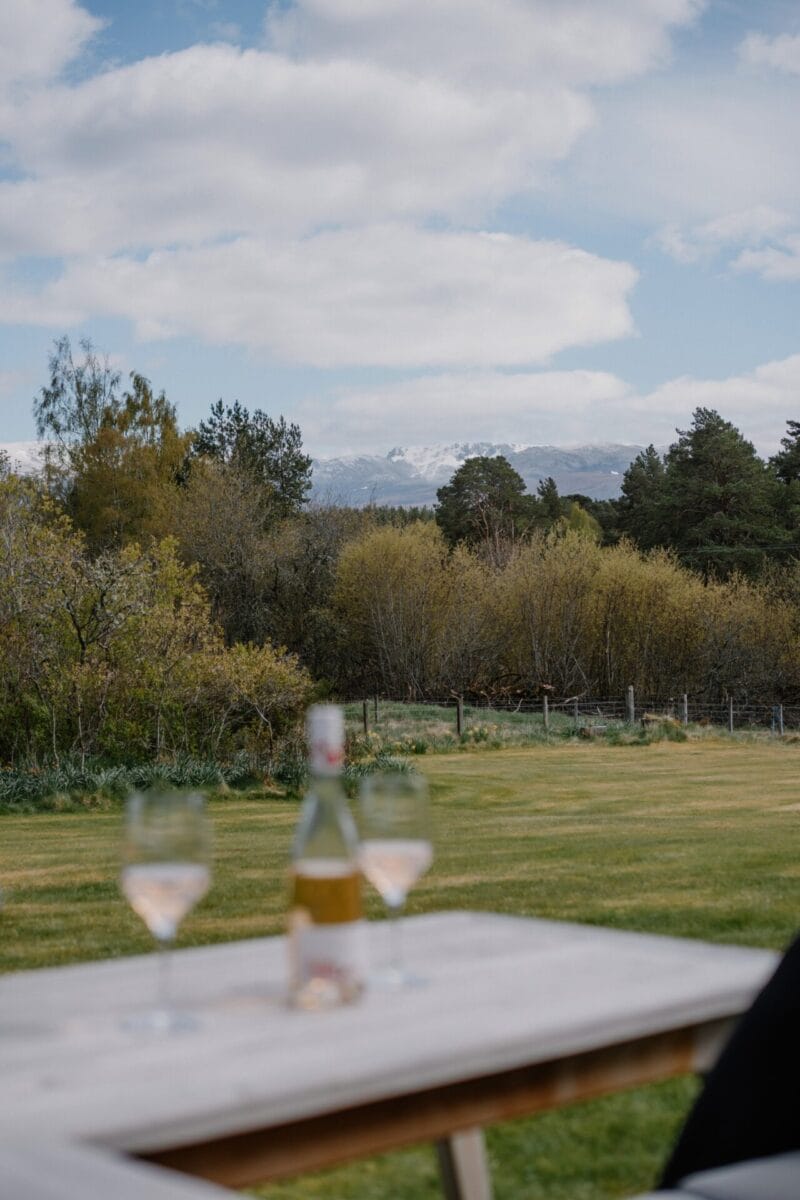 Drinks on the garden table with Cairngorm views at Achnahatnich House, Rothiemurchus, Aviemore
