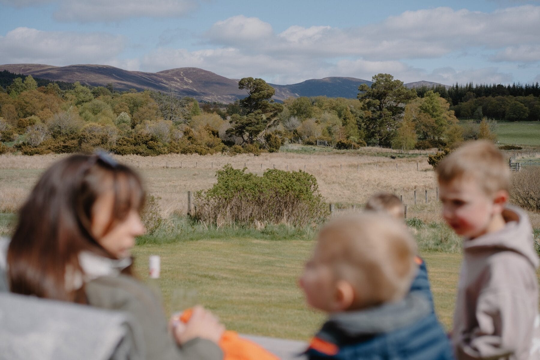 Children in the garden with the mountains behind at Achnahatnich House, Rothiemurchus, Aviemore