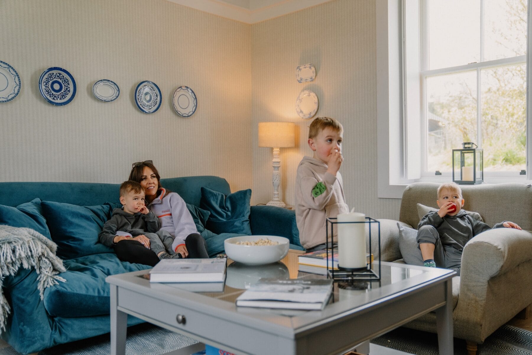 Family relaxing in the sitting room at Achnahatnich House, Rothiemurchus, Aviemore